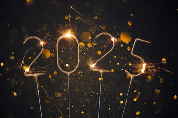 2025 Happy new year Silvester greeting card with burning golden sparklers shiny glitter lights bokeh