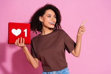 Poster - Photo of adorable pretty positive girl wear brown stylish clothes hold red card look empty space isolated on pink color background