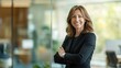© anong - portrait of Happy cheerful professional middle aged business woman corporate leader, smiling positive mature female executive manager standing in office arms crossed looking at camera.
