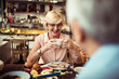 © Davor - Senior couple eating food in cozy restaurant bistro