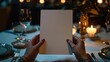 © HideAwayDigitalTH - a branding mockup for a menu design of hands holding a blank menu sitting at a table at a fancy restaurant, direct flash bright flash light candle lit table