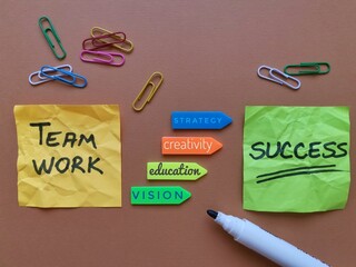 Task concept, business plan of the words Teamwork, Education, Vision, Creativity, Strategy, Success written on colorful sticky notes. Planning a strategy on colored paper with paper clips and marker