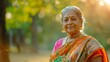 © venusvi - Indian grandmother in a colorful sari and earrings, walking through a park, bright sunlight