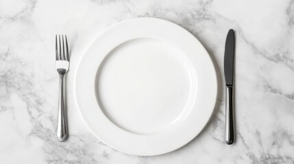 elegant place setting with a white plate, knife, and fork, arranged meticulously, ready for a fine d