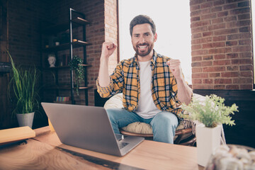 Wall Mural - Photo of lucky funny guy wear plaid shirt enjoying weekend winning game modern gadget indoors room home house