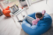 © deagreez - Full body photo of cute small schoolgirl sit bean bag hands behind head relaxed home education school interior