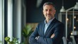 © Hope - Confident smiling middle aged business man attorney, 45 years old senior entrepreneur, mature male professional executive manager leader standing arms crossed in office looking at camera. Portrait