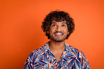 Wall Mural - Photo portrait of handsome young man look up empty space dressed stylish colorful garment isolated on orange color background