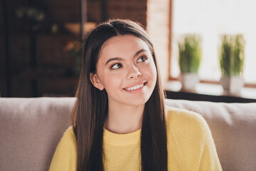 Sticker - Photo portrait of attractive teen woman sit couch look empty space dressed yellow outfit cozy day light home interior living room