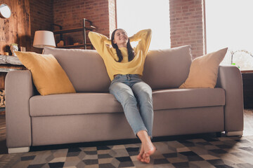 Wall Mural - Full length photo of nice teen lady sit couch relax hands behind head dressed yellow garment spend pastime spacious house indoors room