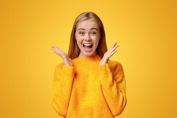 wow. surprised and shocked teen girl opened mouth in amazement over orange studio background