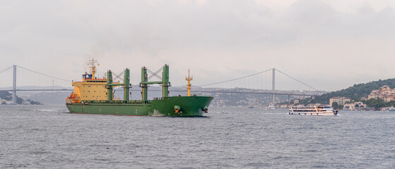 Poster - Cargo vessel cruises through the Bosphorus Strait, passing Istanbul's historic