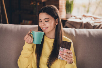 Sticker - Photo portrait of nice teen lady drink tea eat chocolate dressed yellow garment spend pastime spacious house indoors room