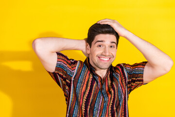 Sticker - Portrait of nice young man arms touch hair wear shirt isolated on yellow color background