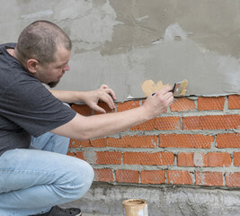 Wall Mural - A man is painting a brick wall