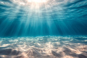 Underwater view of sandy sea bottom with sunbeams and rays