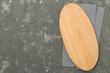 © Liami - Cutting board with napkin on concrete background, top view