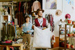 © AnnaStills - Smiling persons standing together inside a colorful boutique filled with various items of clothing and plants, creating a vibrant and lively setting