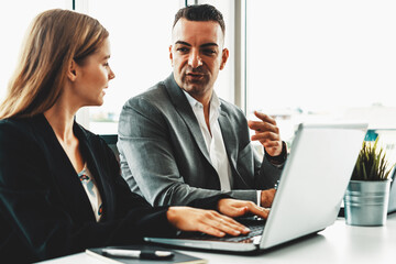 Wall Mural - Businessman executive is in meeting discussion with a businesswoman worker in modern workplace office. People corporate business team concept. uds