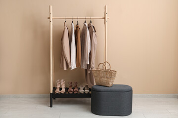 Wall Mural - Female clothes hanging on rack against beige background