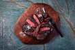 © HLPhoto - Traditional barbecue dry aged wagyu porterhouse beef steak bistecca alla Fiorentina sliced with salt and pepper served as top view on a wooden design board with a Japanese knife