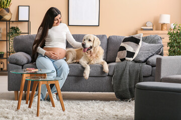 Wall Mural - Beautiful pregnant woman with dog on sofa at home