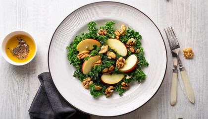 Wall Mural - Kale apple walnut salad on a white dinner plate vinaigrette