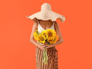 Sticker - Beautiful young woman in wicker hat with bouquet of sunflowers on orange background