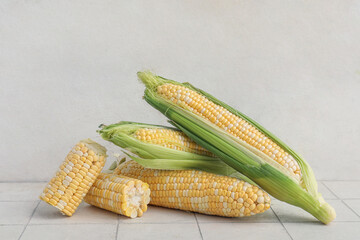 Wall Mural - Fresh corn cobs on white tile table