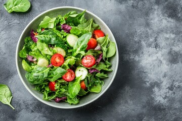 Wall Mural - Green vegan salad from green leaves mix and vegetables. Top view on gray stone table. - generative ai