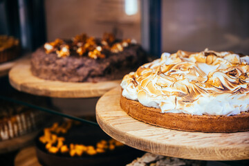 Lemon meringue cake and chokolate nut cake in sale in a bakery of a coffee shop.