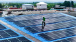 © ultramansk - top aerial of engineer men inspects construction of solar cell panel or photovoltaic cell at roof top. Industrial Renewable energy of green power. factory at urban area. worker working on tower roof.