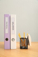 Wall Mural - Folders with words Payroll and Salaries, holder with pencils on wooden table