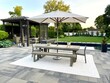 © theplantedwanderer - High-end outdoor living space, a backyard patio with pergola, outdoor rug,  tequila bar, dining set, couch, television, pool with waterfall, umbrella, fire pit and stunning grey patio. Modern vibe.
