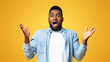 © Prostock-studio - Portrait of surprised african american man standing with opened mouth and raised hands, yellow studio background