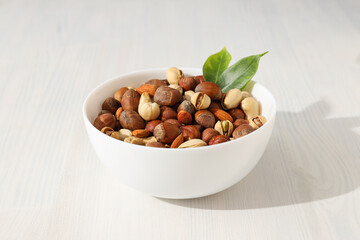 Wall Mural - Assorted nuts in white bowls on a light background