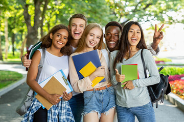 Portrait of international happy students posing in park, walking in city after studying