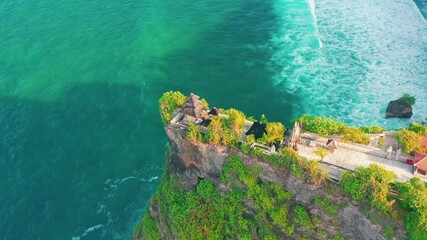 Wall Mural - Bali's Most Iconic Landmark and popular tourist attraction Bali temple, Uluwatu temple one of six key Balinese hindu temple perched on top mountain cliff on nature background Bali, Indonesia 4K Aerial