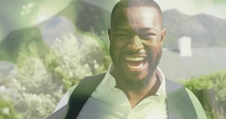 Wall Mural - Smiling man outdoors with bokeh light animation over mountains in background