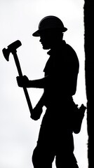 A man in a black shirt and hat is holding a hammer and a large axe. He is wearing a hard hat and he is a construction worker