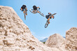 © Michael Cunningham/peopleimages.com - Jump, cycling and person on dirt bike with adventure, adrenaline and speed in stunt competition, Extreme sport, trick and athlete on bicycle challenge, talent or energy on action course in composite