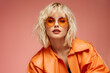 © Jati - blond woman with sunglasses and orange jacket posing for a picture