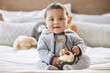 © Flashizzle/peopleimages.com - Portrait, baby and play with toy in bedroom for fine motor skills, creative learning and sensory development at house. Happy child, boy and fun with nursery, cognitive education and mobility growth
