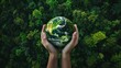 © Johannes - Hands holding globe on green nature forest background in saving environment concept, save clean planet, ecology concept for World Earth Day. Aerial top view green forest with earth, Green planet.