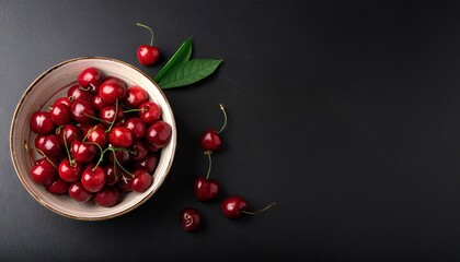 Wall Mural - cherry in a bowl on a black background, top view, copy space 