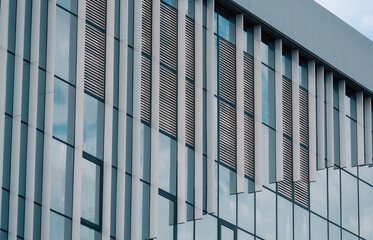 empty glass windows of a modern building with a reflection of the sky in the glass