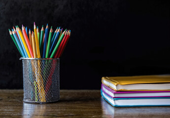 Aufkleber - Back to school concept with colorful pencils in metal pot and books on wooden table with blackboard background