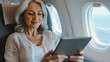 © Andrii  - Middle-Aged Businesswoman Managing Tasks on Airplane