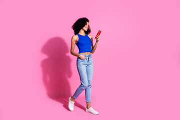 Poster - Photo of girl smiling walking using cell smart gadget looking isolated pastel color background