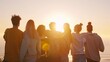 © VK Studio - A close-knit group of friends watch the sunset together, their silhouettes blending into a serene horizon, embodying warmth and camaraderie.